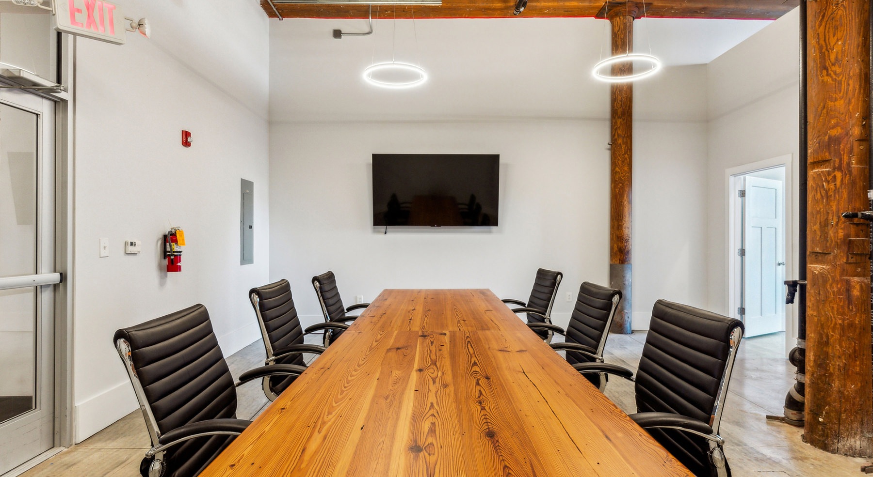 a conference room with a large table chairs and tv