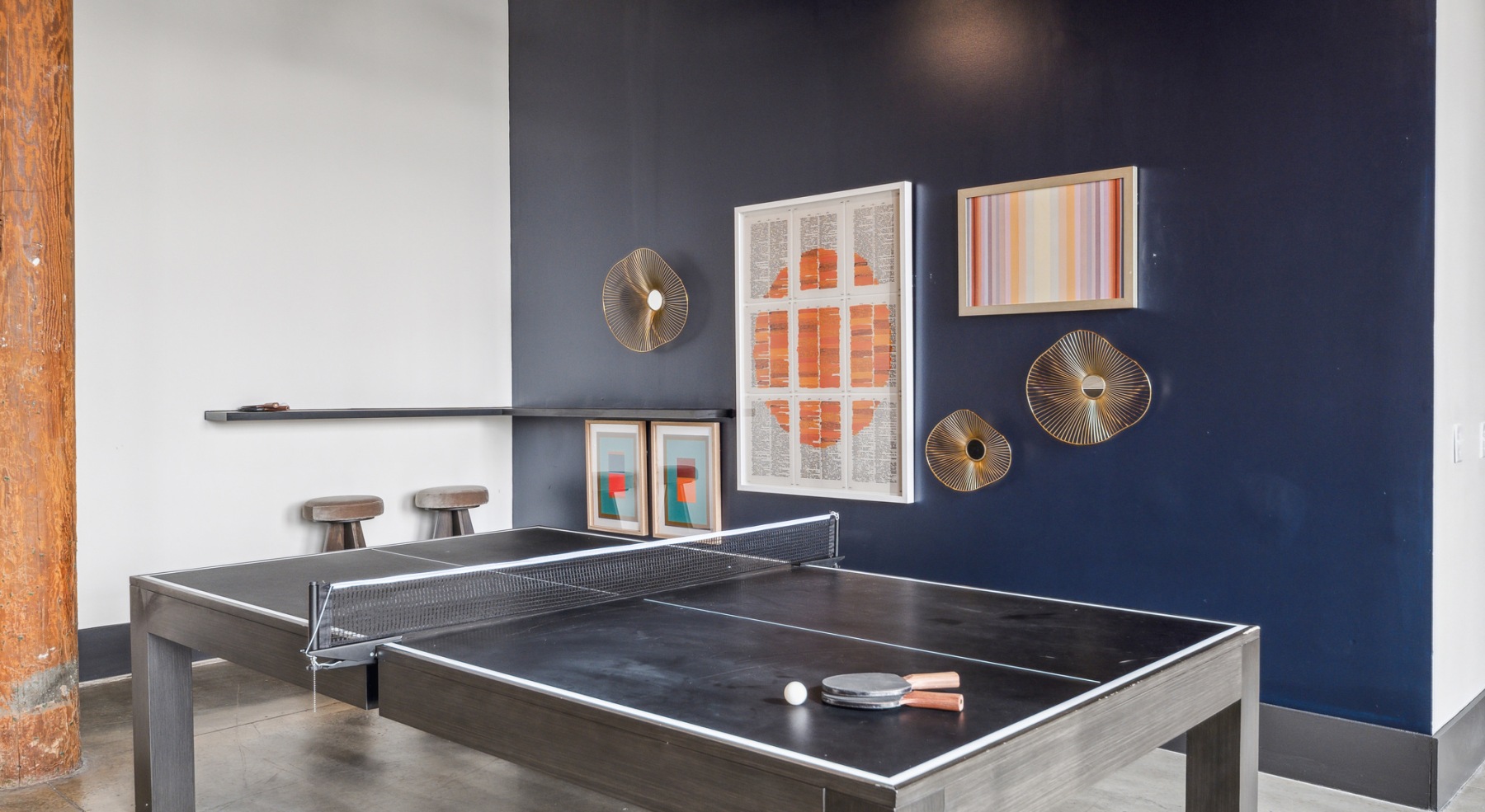 ping pong table in a room with art on the wall