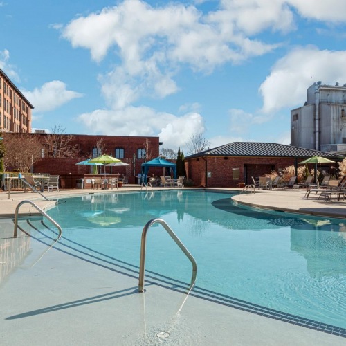 A perfect fit for the whole family a pool with a building in the background