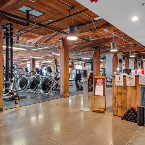 Everything within reach a large room with a lot of weights and a large wood floor